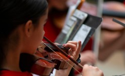 A member of the Youth Symphony Orchestra of East Central Indiana plays the violin during their April 13 performance in the Muncie Mall. Breanna Daugherty | SFG