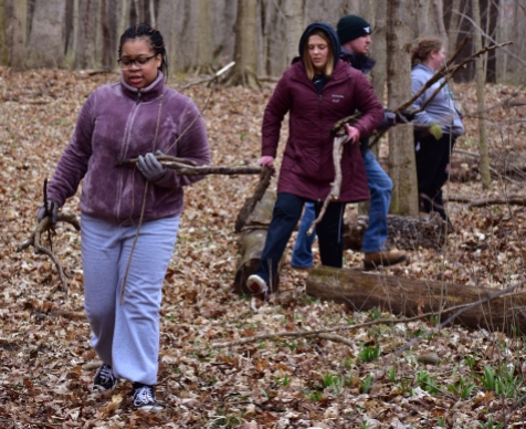 A group of Red-Tail Land Conservancy volunteers helping scatter wood and debris throughout Munsee Woods in Muncie, IN, on April 9th, 2022. (JOUR 437 / Alex Lakes)